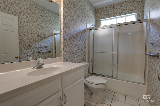 full bathroom with combined bath / shower with glass door, tile patterned flooring, vanity, and toilet