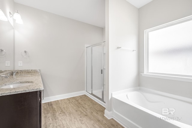 31689 Kestrel Loop, Spanish Fort, AL 36527 - bathroom featuring a bath, a stall shower, wood finished floors, double vanity, and baseboards