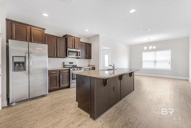 31689 Kestrel Loop, Spanish Fort, AL 36527 - kitchen with stainless steel appliances, a sink, light wood finished floors, a chandelier, and dark brown cabinets