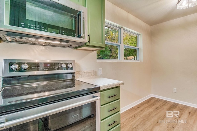 kitchen with appliances with stainless steel finishes, light wood-type flooring, and green cabinetry