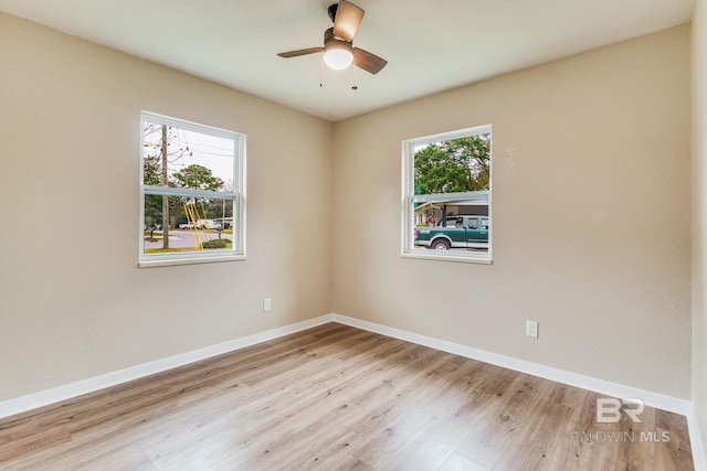 unfurnished room featuring plenty of natural light, ceiling fan, and light wood-type flooring