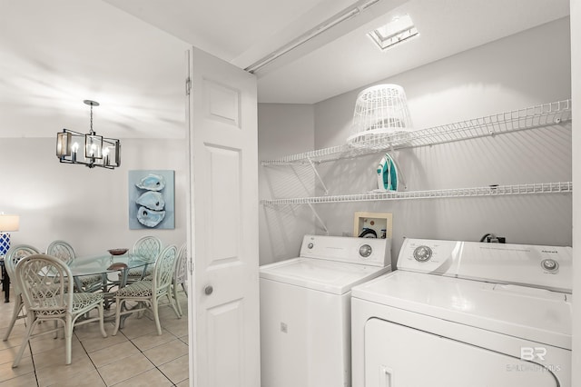 laundry room with a chandelier, laundry area, washer and clothes dryer, and light tile patterned floors