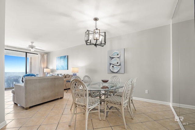 dining area with light tile patterned floors, baseboards, and ceiling fan with notable chandelier