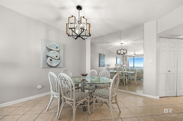 dining space with an inviting chandelier, baseboards, and light tile patterned flooring