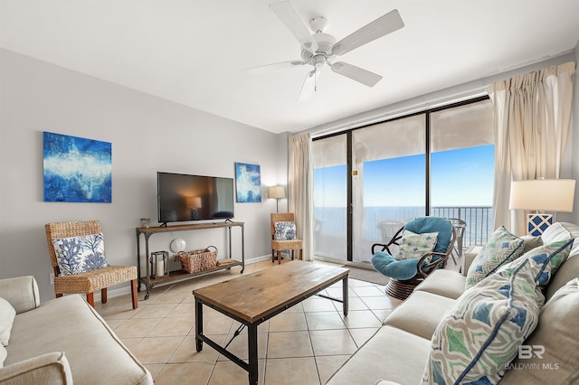 living room with light tile patterned flooring, a ceiling fan, and baseboards