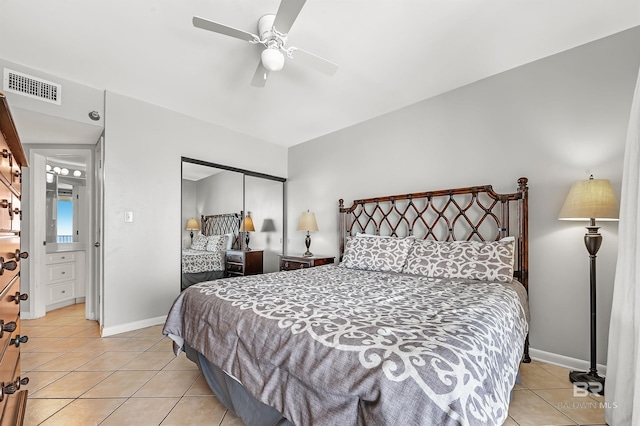 bedroom featuring light tile patterned floors, visible vents, baseboards, a ceiling fan, and a closet