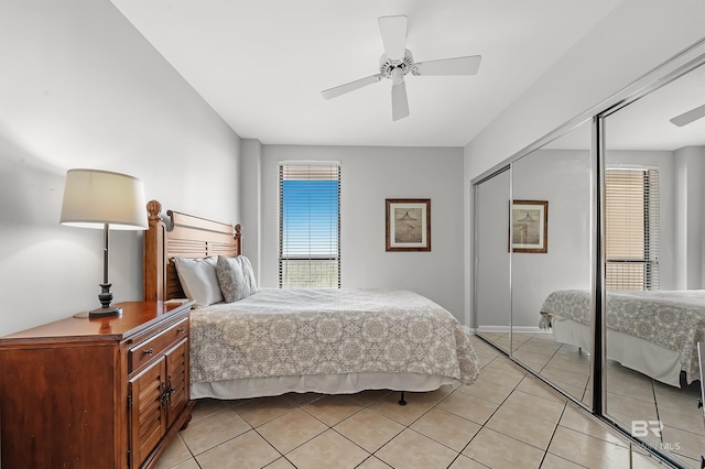 bedroom featuring ceiling fan, a closet, and light tile patterned flooring