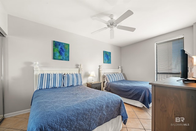 bedroom with light tile patterned floors, ceiling fan, and baseboards