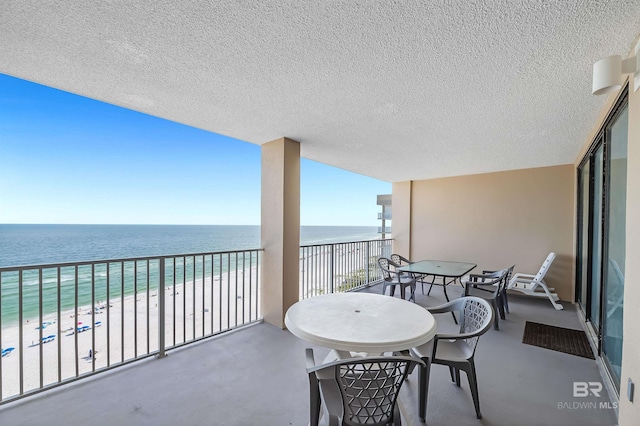 balcony featuring a water view and a view of the beach