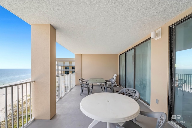 balcony featuring a water view and outdoor dining area