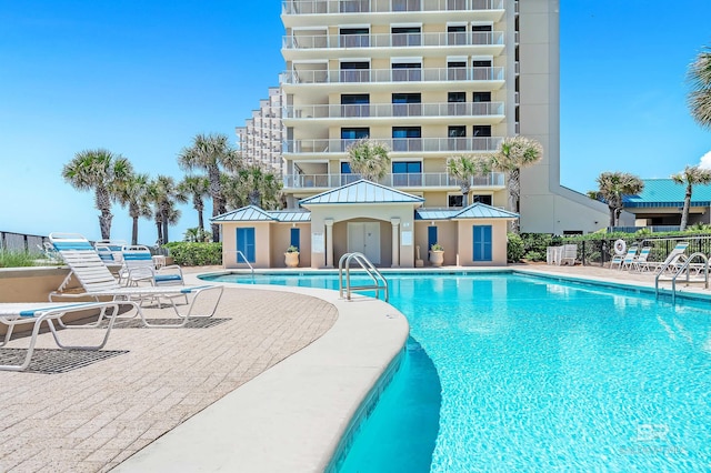 pool with a patio area and fence