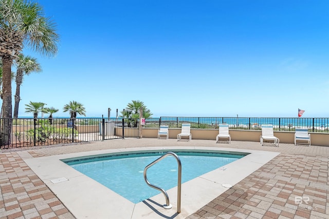 community pool with a patio area and fence