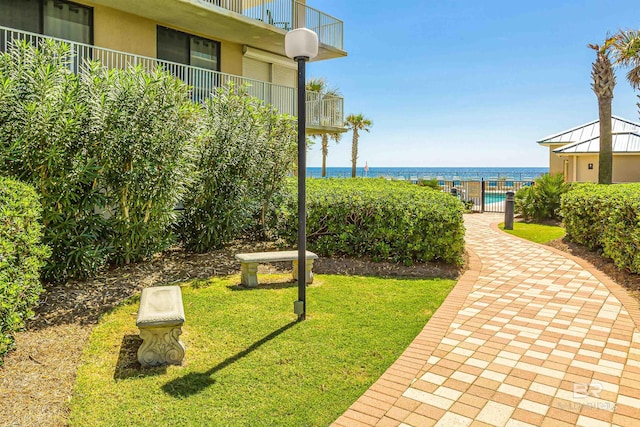 view of home's community with a water view and a yard