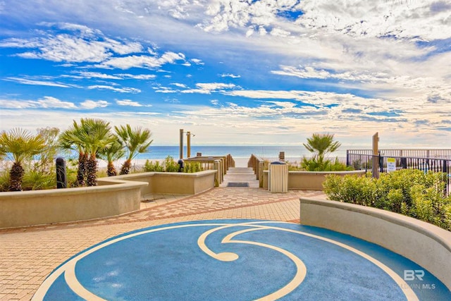 view of swimming pool with a water view and fence