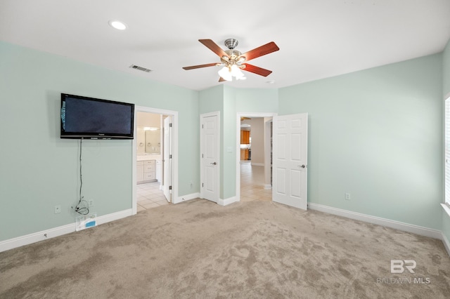 unfurnished bedroom with light carpet, ensuite bath, and ceiling fan