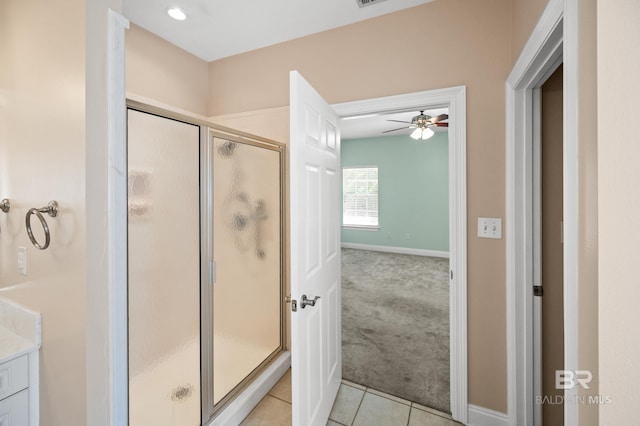 bathroom featuring ceiling fan, tile patterned flooring, a shower with shower door, and vanity