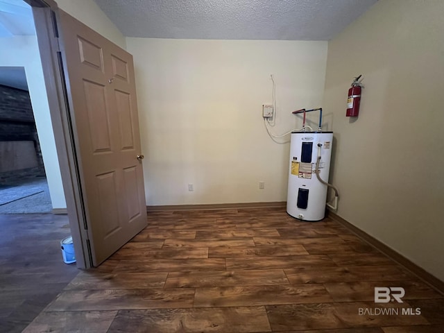 interior space featuring dark wood-type flooring, water heater, and a textured ceiling