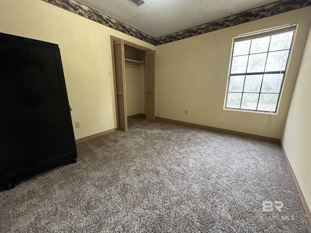 unfurnished bedroom featuring carpet floors, a closet, and a textured ceiling