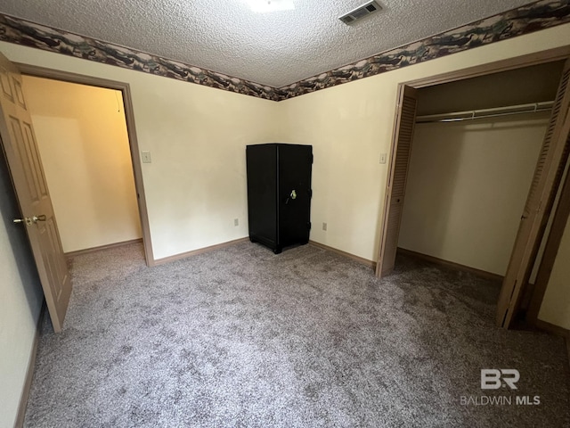 unfurnished bedroom with carpet floors, a closet, and a textured ceiling