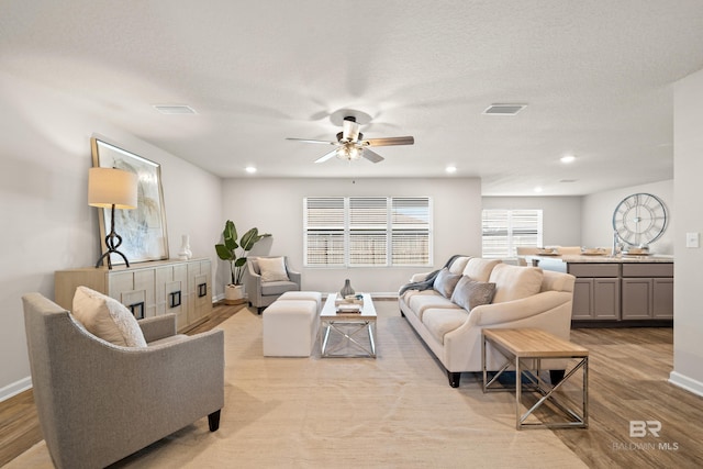 living room with ceiling fan and light wood-type flooring