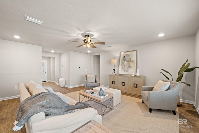 living room featuring ceiling fan and light hardwood / wood-style flooring