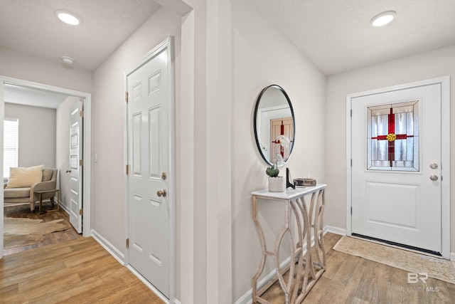 foyer entrance featuring a textured ceiling and light wood-type flooring