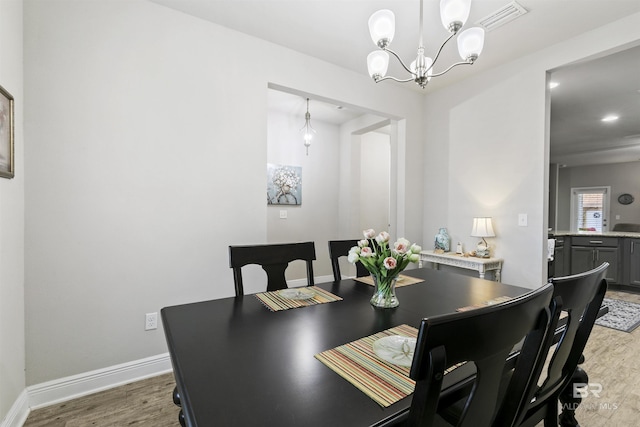 dining room with an inviting chandelier and hardwood / wood-style flooring