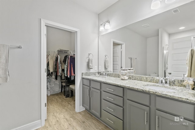 bathroom featuring wood-type flooring, toilet, and vanity