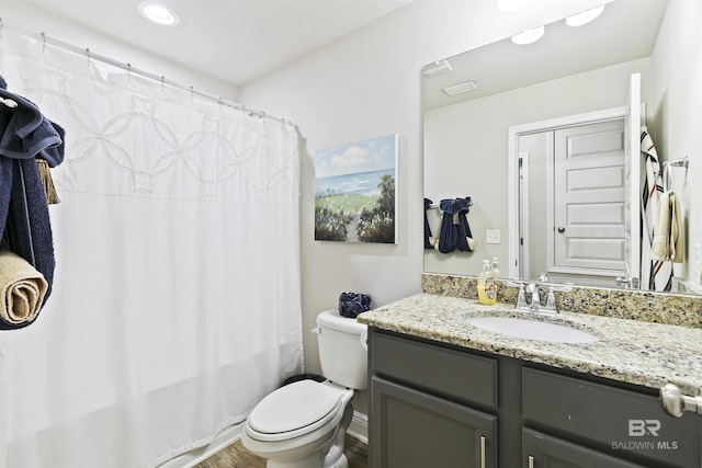 bathroom featuring toilet, hardwood / wood-style floors, and vanity