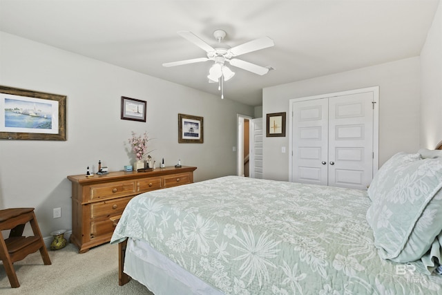 carpeted bedroom featuring ceiling fan and a closet