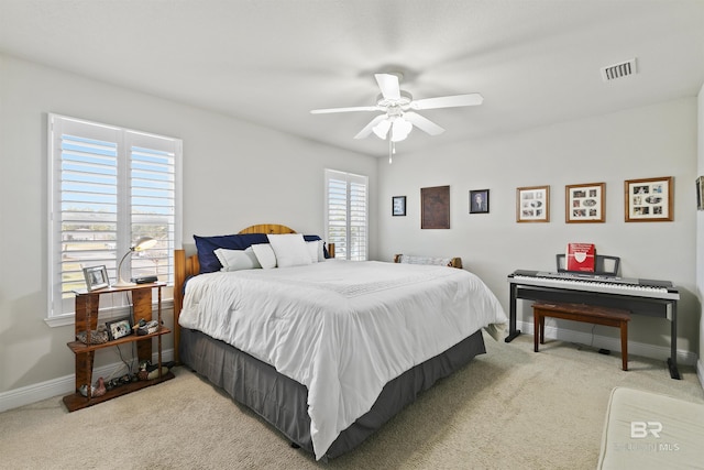 carpeted bedroom with ceiling fan and multiple windows