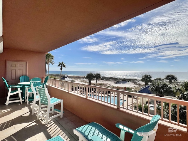 balcony featuring a water view and a beach view