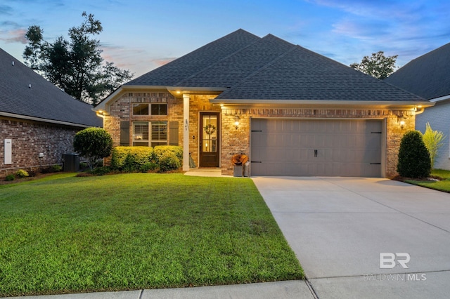 view of front facade featuring cooling unit, a yard, and a garage