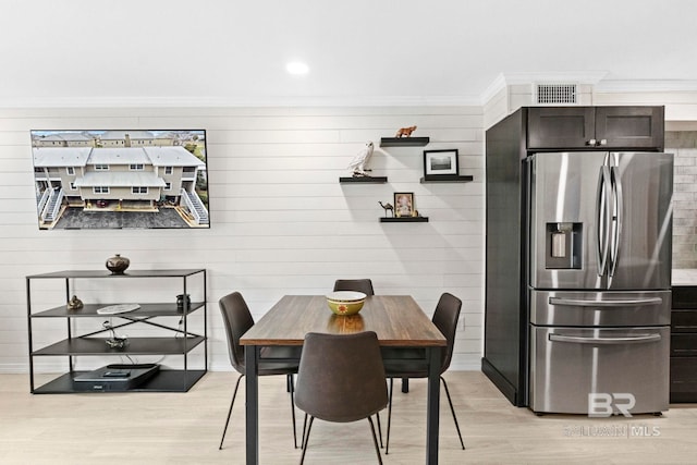 dining area with light wood-type flooring and crown molding