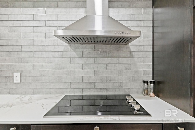 kitchen featuring light stone counters, extractor fan, and black electric stovetop