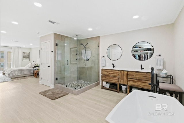 bathroom with crown molding, hardwood / wood-style flooring, separate shower and tub, and vanity