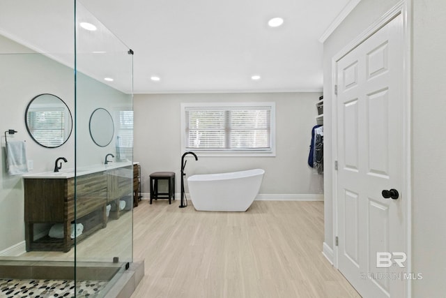 bathroom featuring plus walk in shower, crown molding, vanity, and wood-type flooring