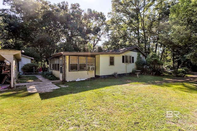 rear view of property with cooling unit and a yard