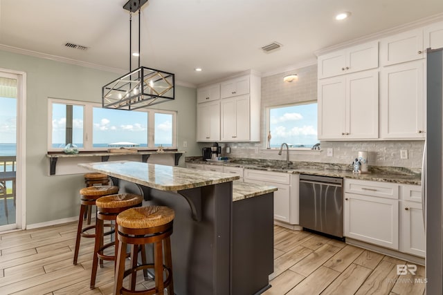 2802 Bienville Blvd, Dauphin Island, AL 36528 - kitchen featuring crown molding, light wood-style flooring, dishwasher, and tasteful backsplash