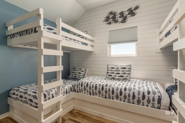 2802 Bienville Blvd, Dauphin Island, AL 36528 - bedroom featuring wood walls, wood finished floors, and vaulted ceiling