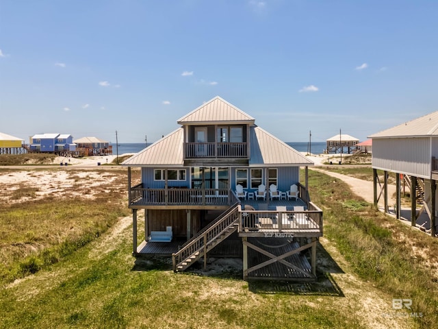 2802 Bienville Blvd, Dauphin Island, AL 36528 - rear view of property featuring a wooden deck, a balcony, stairs, metal roof, and a lawn