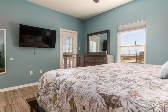 2802 Bienville Blvd, Dauphin Island, AL 36528 - bedroom with baseboards, ceiling fan, wood finished floors, and access to exterior