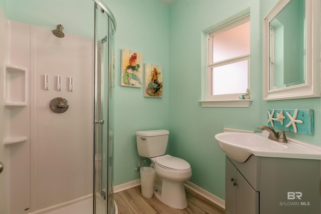 2802 Bienville Blvd, Dauphin Island, AL 36528 - full bathroom featuring vanity, toilet, baseboards, wood finished floors, and a stall shower