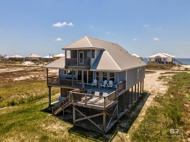2802 Bienville Blvd, Dauphin Island, AL 36528 - rear view of house featuring a lawn, a deck, metal roof, and a balcony