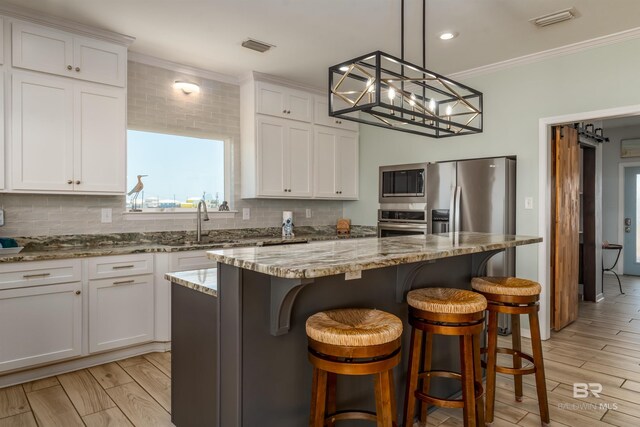 2802 Bienville Blvd, Dauphin Island, AL 36528 - kitchen featuring stainless steel appliances, ornamental molding, and white cabinetry