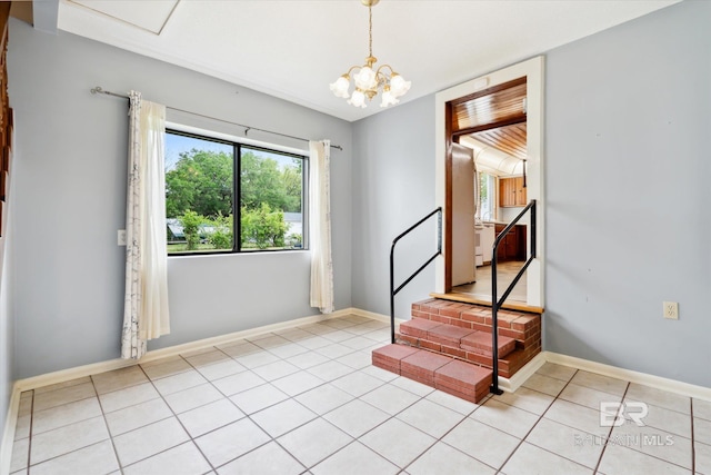 tiled empty room featuring a notable chandelier