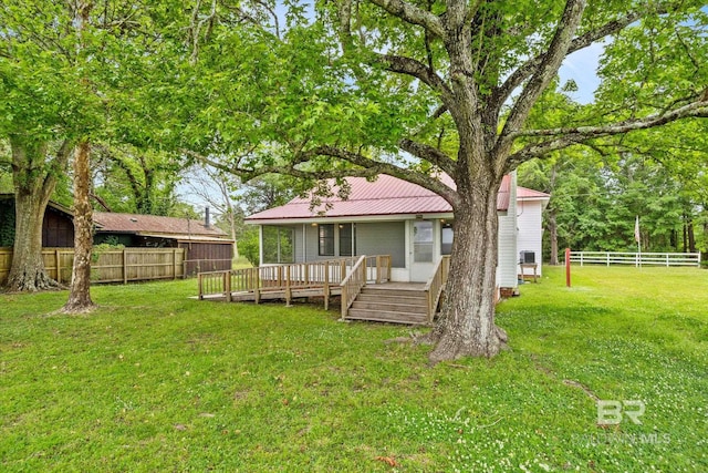 back of house with a deck and a lawn