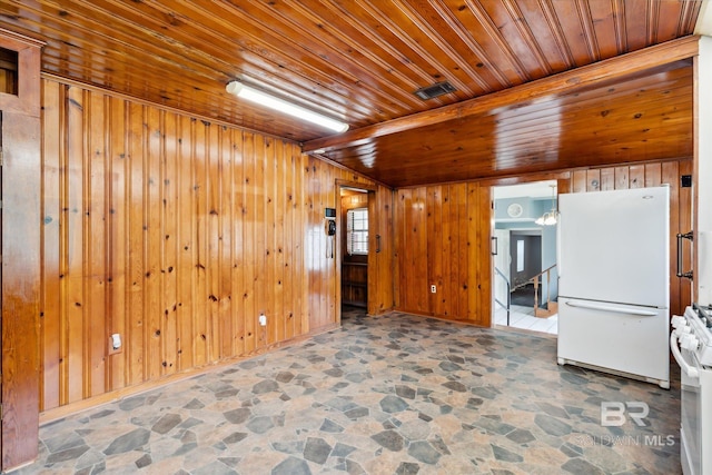 unfurnished room with wooden ceiling and wood walls