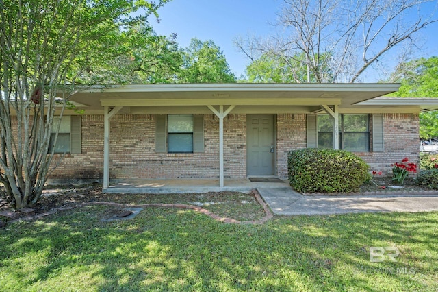 ranch-style home featuring brick siding, a front yard, and a porch