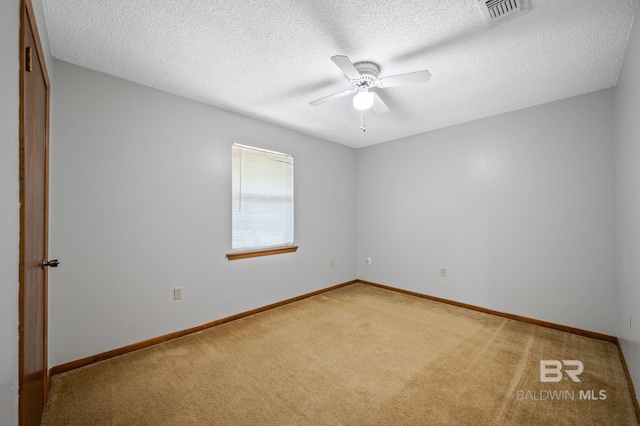 unfurnished room featuring carpet, visible vents, baseboards, and a ceiling fan